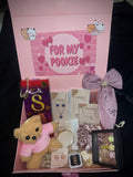 Luxury gift hamper for girlfriend featuring a teddy bear, jewelry, chocolates, and decorative items.