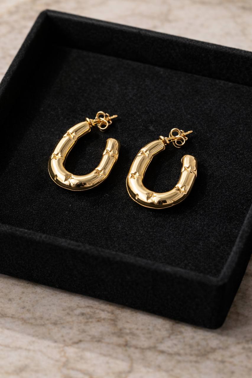 Gold hoop earrings on a black velvet display box.