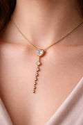 Delicate gold necklace with heart-shaped pendant on a person's neck