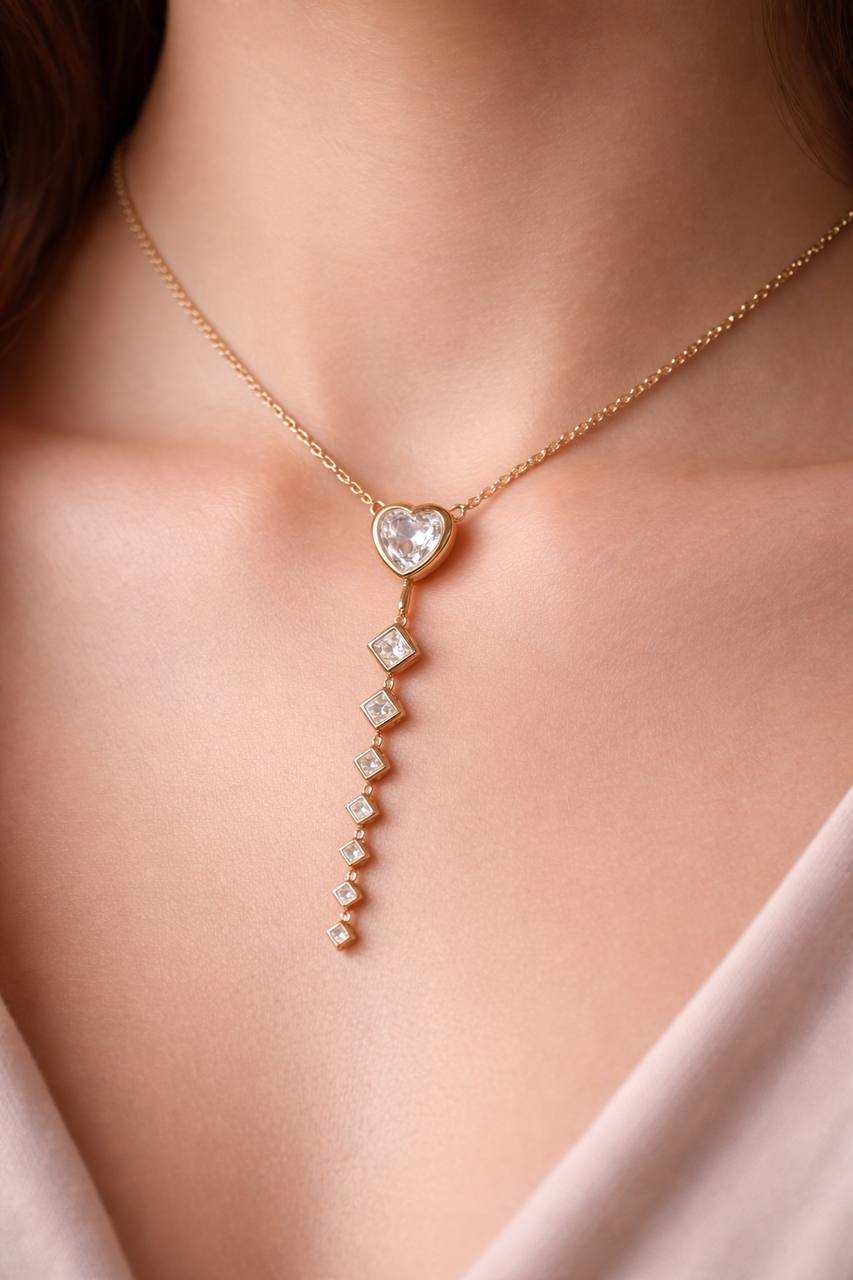 Delicate gold necklace with heart-shaped pendant on a person's neck