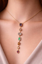 Gold necklace with colorful gemstones on a person's neck