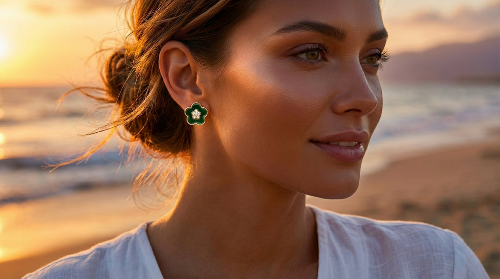 Woman wearing green earrings on a beach at sunset