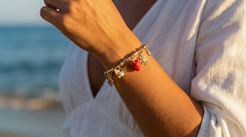 Person wearing a bracelet with charms by the ocean