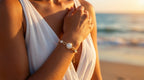Woman wearing a bracelet with a sunset and beach in the background
