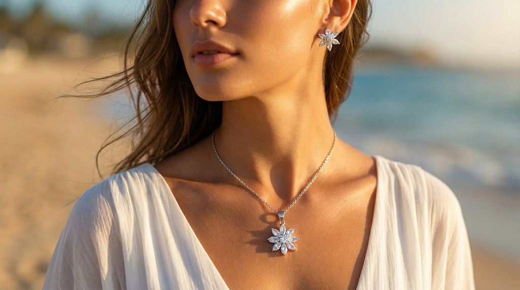 Woman wearing a silver necklace and earrings with a blurred beach background
