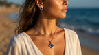 Woman on a beach wearing a necklace with a blue pendant