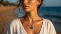 Woman wearing a necklace with a blue pendant on a beach