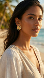 Woman wearing gold earrings on a beach
