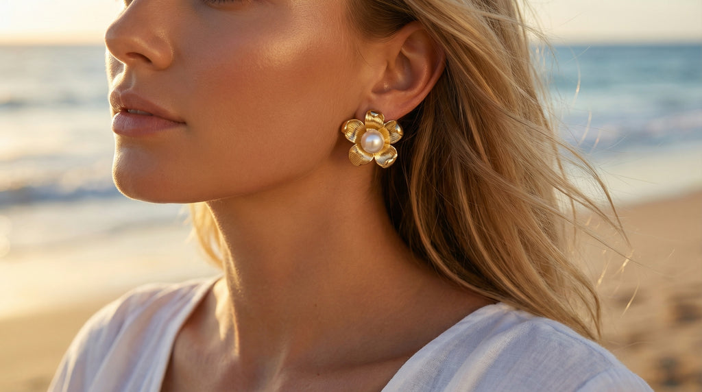 Woman wearing pearl earrings with a beach background