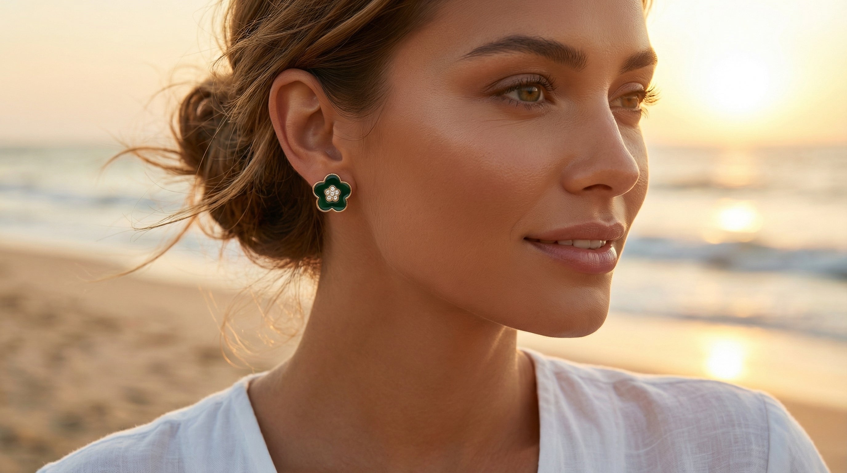Woman wearing earrings on a beach at sunset