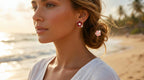 Woman on a beach with floral earrings, sunset in the background