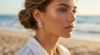 Woman wearing pearl earrings on a beach