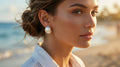 Woman wearing pearl earrings on a beach