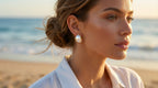 Woman wearing pearl earrings on a beach