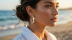 Woman wearing large hoop earrings on a beach