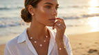 Woman on a beach wearing a necklace and bracelet with a blurred background