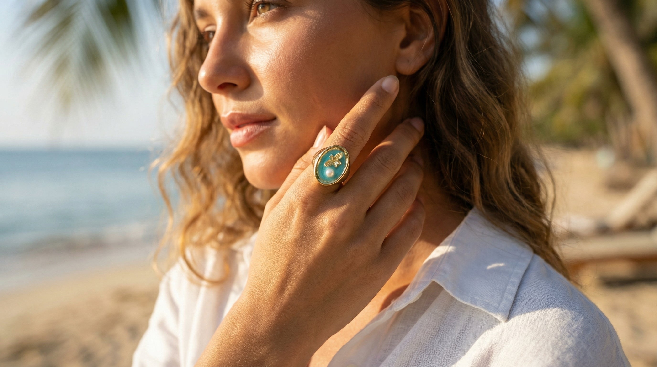 Woman on a beach wearing a ring with a turquoise stone