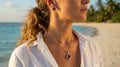 Woman on a beach wearing earrings and a necklace with a scenic background