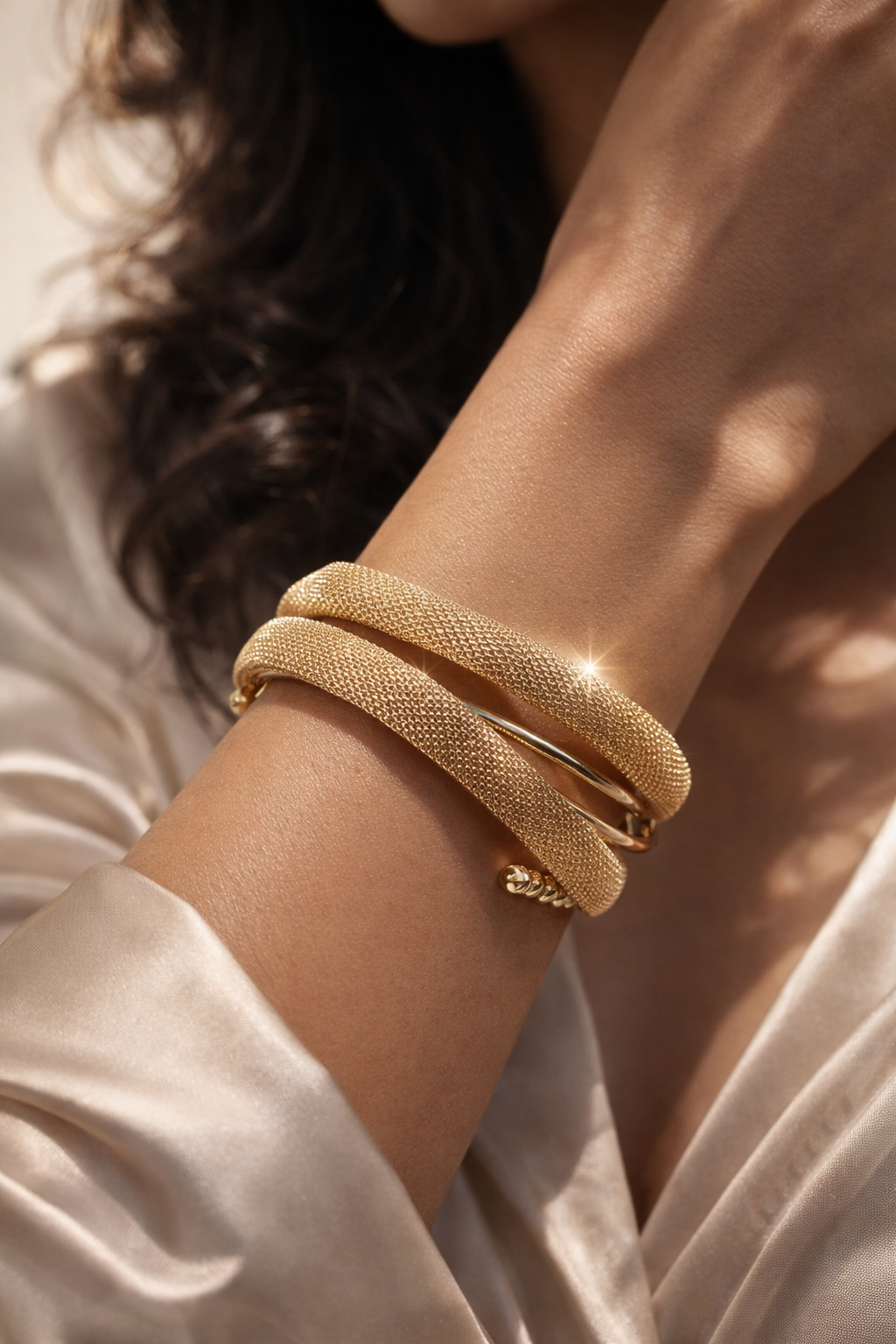 "ZOMARA Gold Mesh Wrap Coil Bracelet worn on wrist — thick gold-tone mesh coiled in double-wrap silhouette, styled against warm skin tone in editorial shot