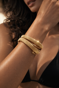 Gold bracelet on a wrist with a blurred background