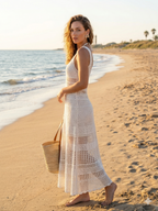 Woman in a white crochet dress on a beach