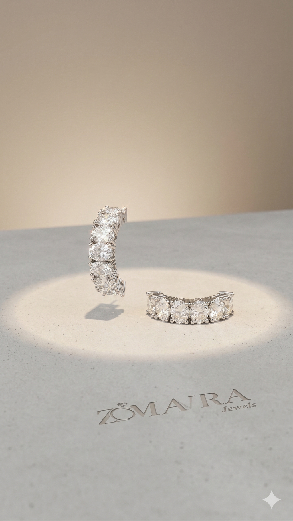 Pair of diamond earrings on a branded stand with Zomra Jewels logo.