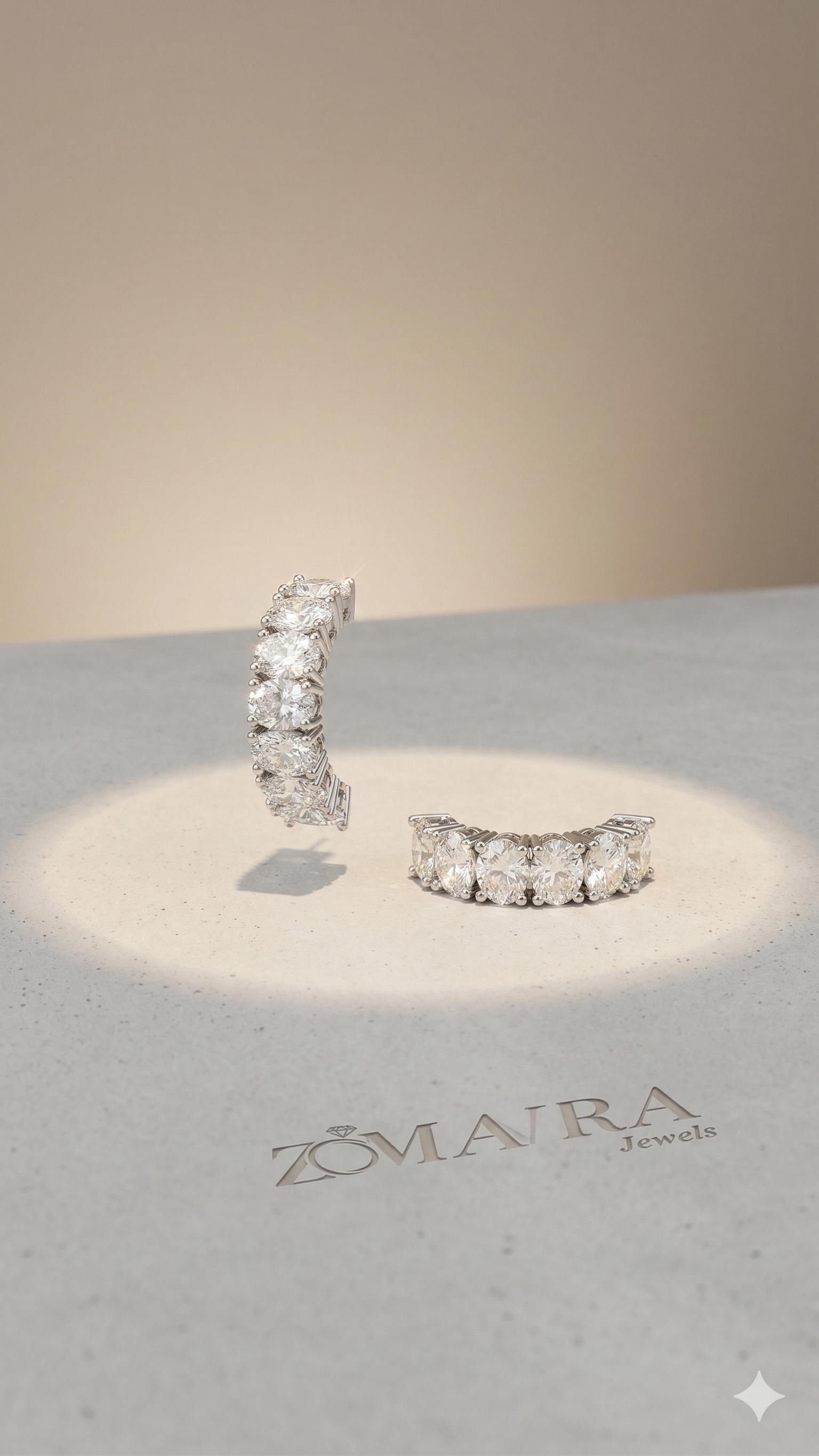 Pair of diamond earrings on a branded stand with Zomra Jewels logo.