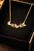Gold butterfly necklace on a dark background