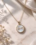 Gold necklace with a pendant displaying '11:11' on a marble surface.