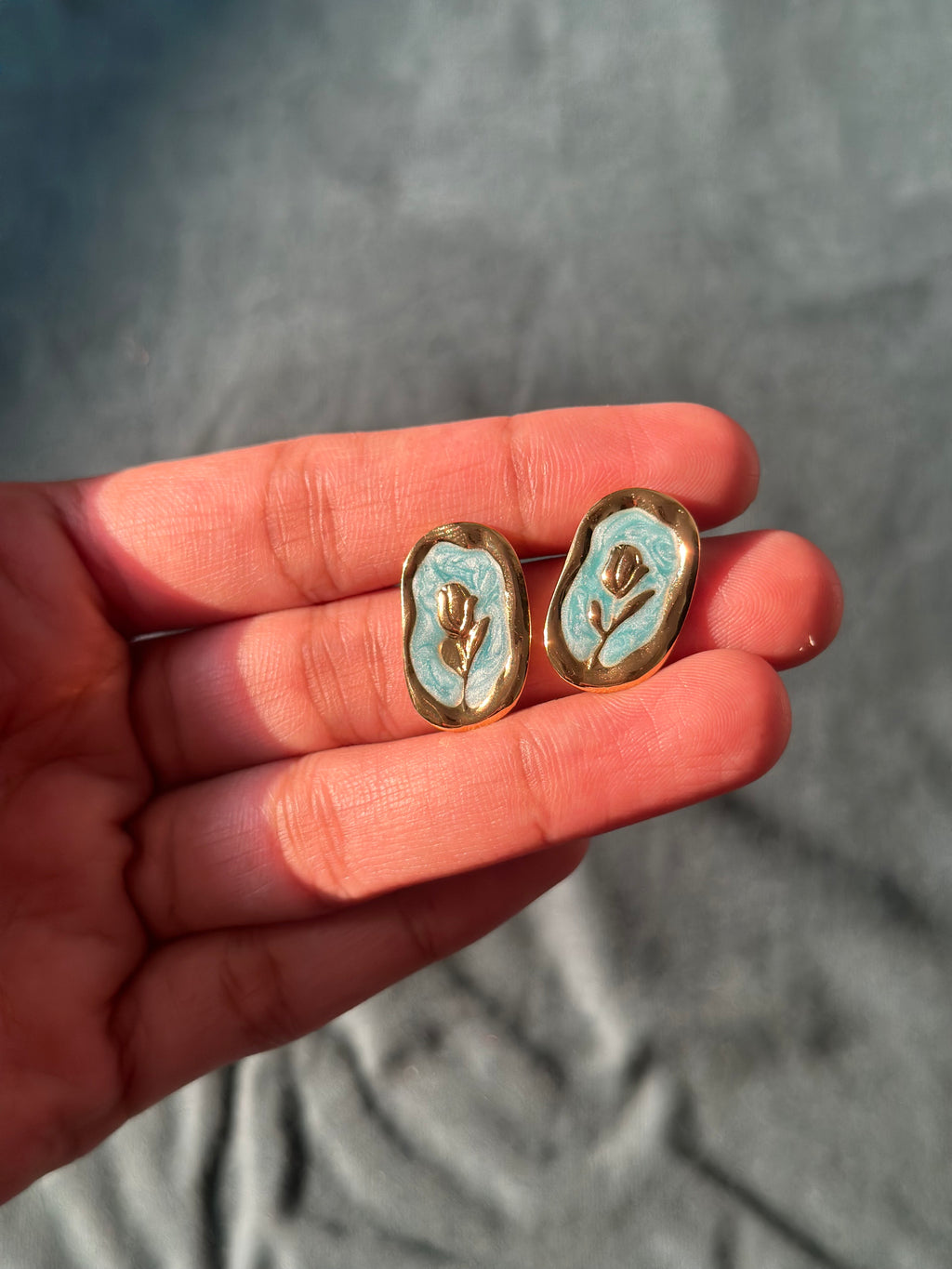 Pink floral stud earrings with gold tone border
