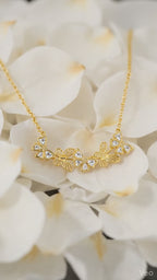 Delicate gold-toned necklace featuring butterfly and flower pendants embellished with sparkling crystals

