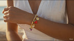 Woman on a beach wearing colorful bracelets with a blurred ocean background