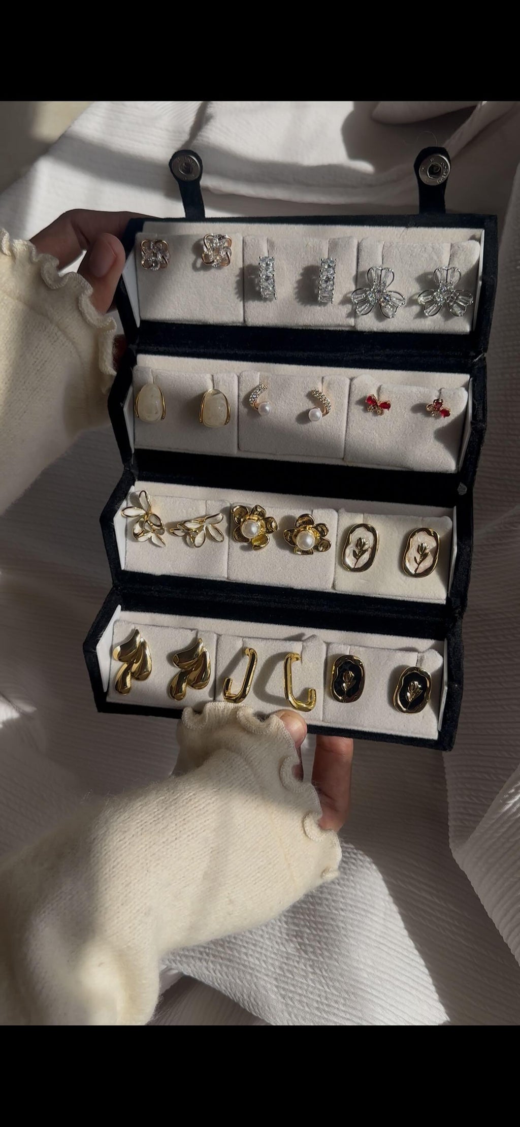 12-pair vintage-inspired earring set featuring crystal flowers, butterfly earrings, pearl studs, botanical designs, cameo-style floral earrings, and modern gold-tone statement earrings displayed in a jewelry organizer.