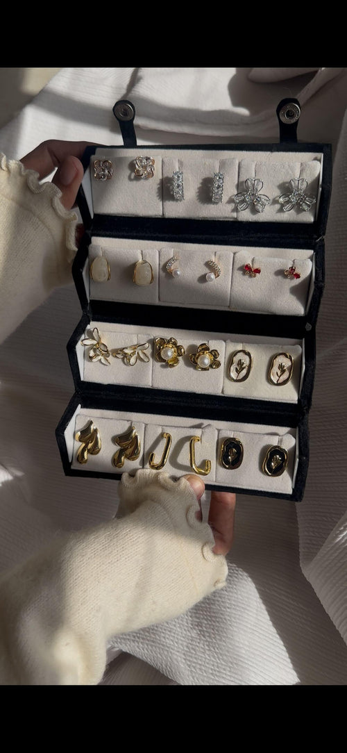 12-pair vintage-inspired earring set featuring crystal flowers, butterfly earrings, pearl studs, botanical designs, cameo-style floral earrings, and modern gold-tone statement earrings displayed in a jewelry organizer.